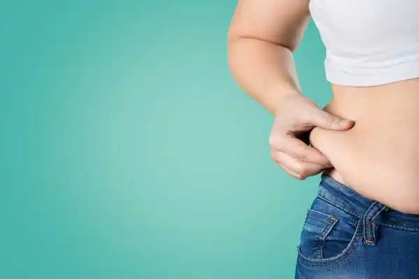 Image of woman pinching her love handles to show weight gain Oakham